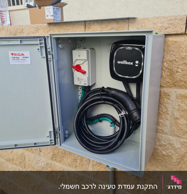 תיבת חשמל פתוחה עם כבל טעינה חשמלי